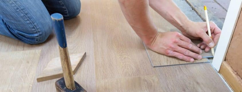 Hamilton homeowner comparing flooring samples on basement floor